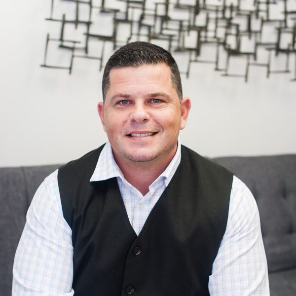 A man sitting on top of a couch in front of a wall.