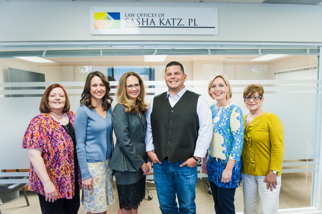 A group of people standing in front of a sign.